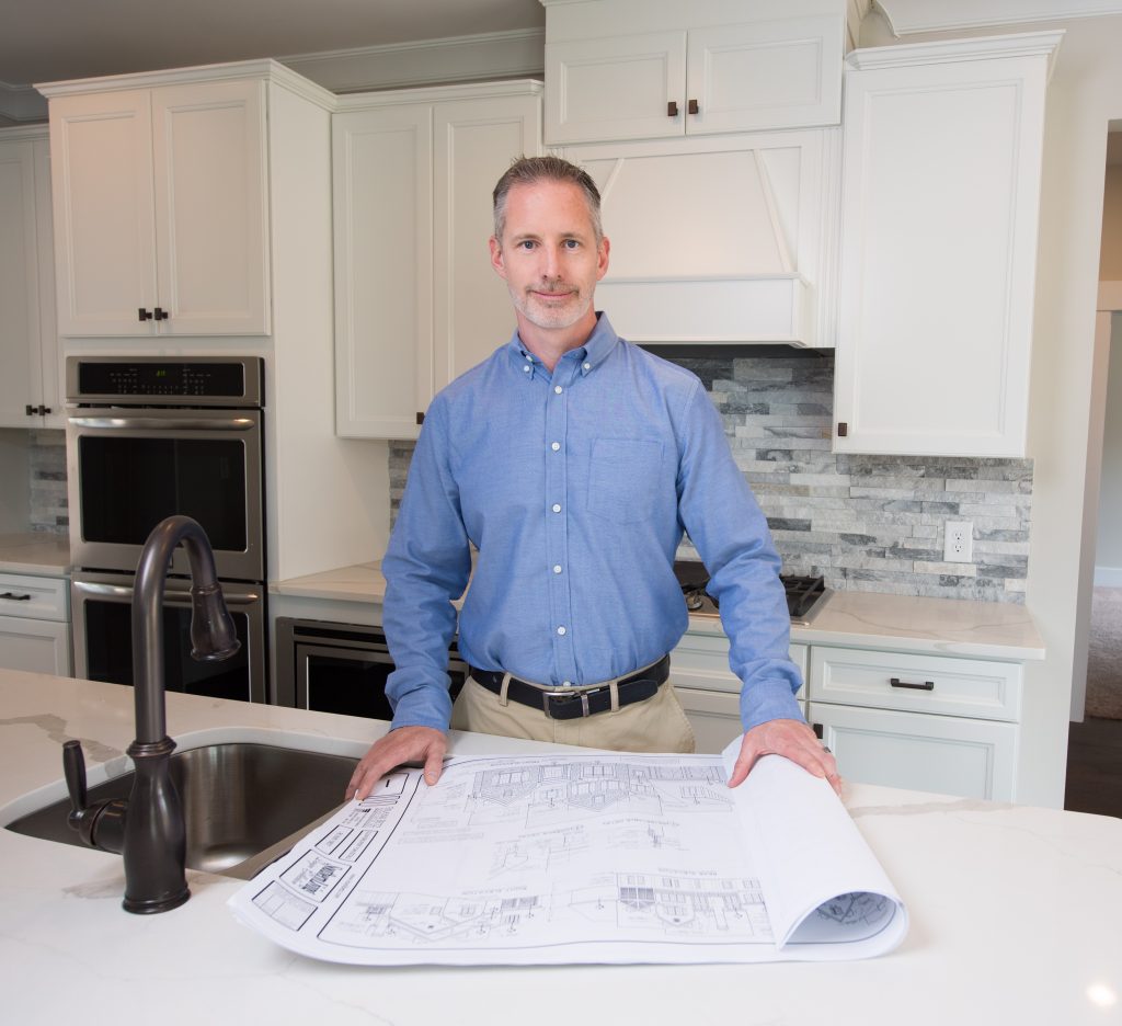 Man Holding Blueprint for a Custom Home