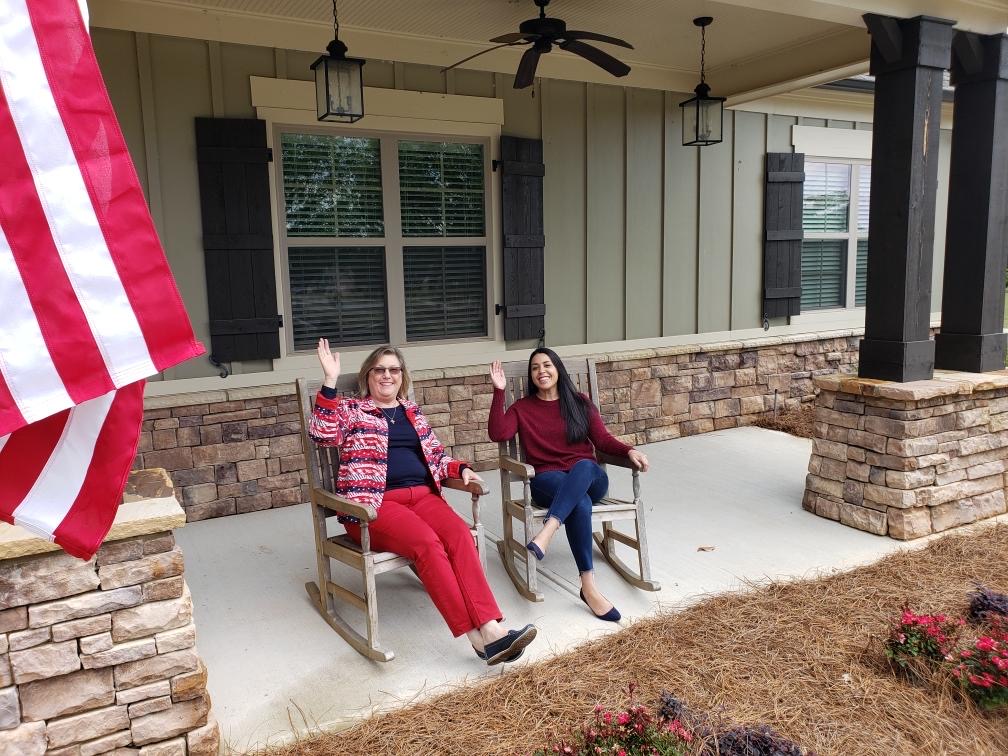 Friendly Traditions of Braselton staff waving while sitting on porch