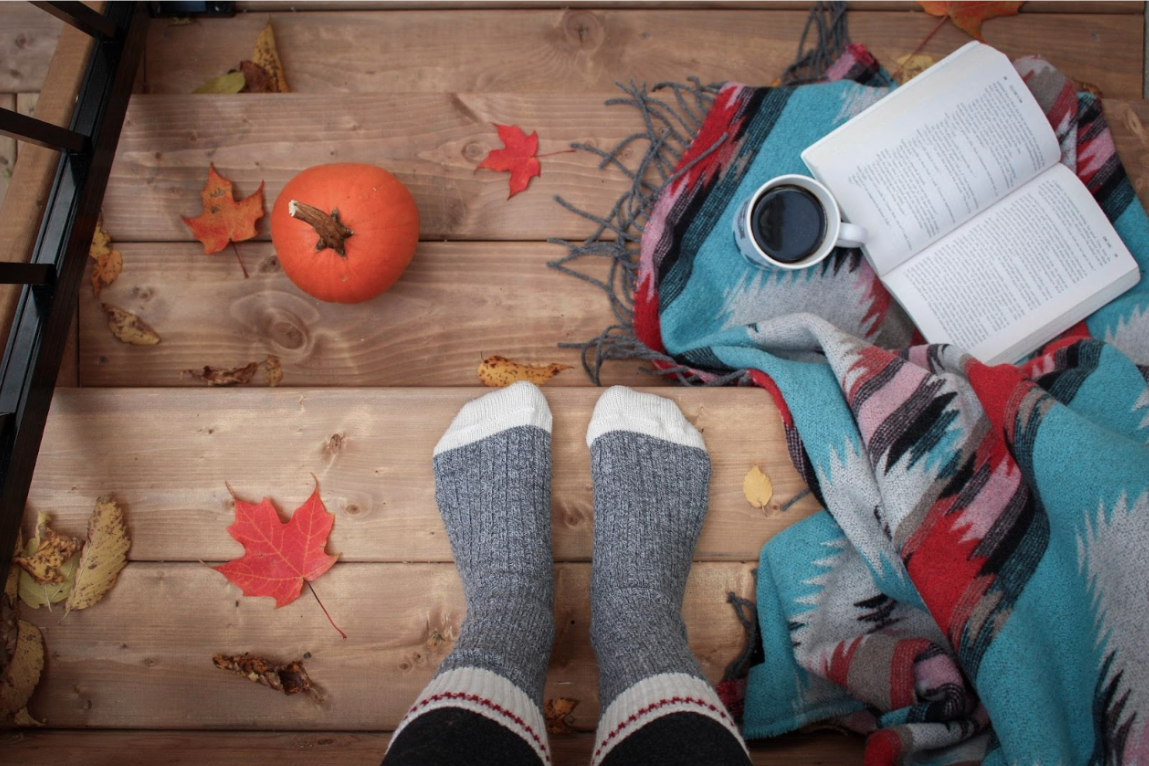 porch with pumpkin, book, and fall leaves.