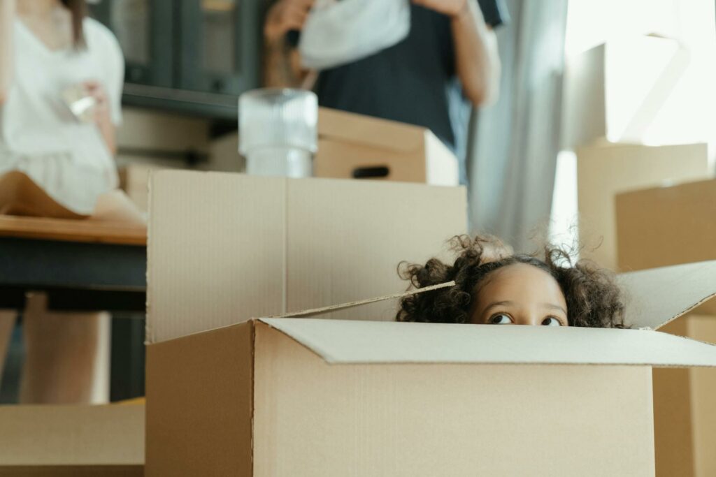 young girl hiding in a cardboard box