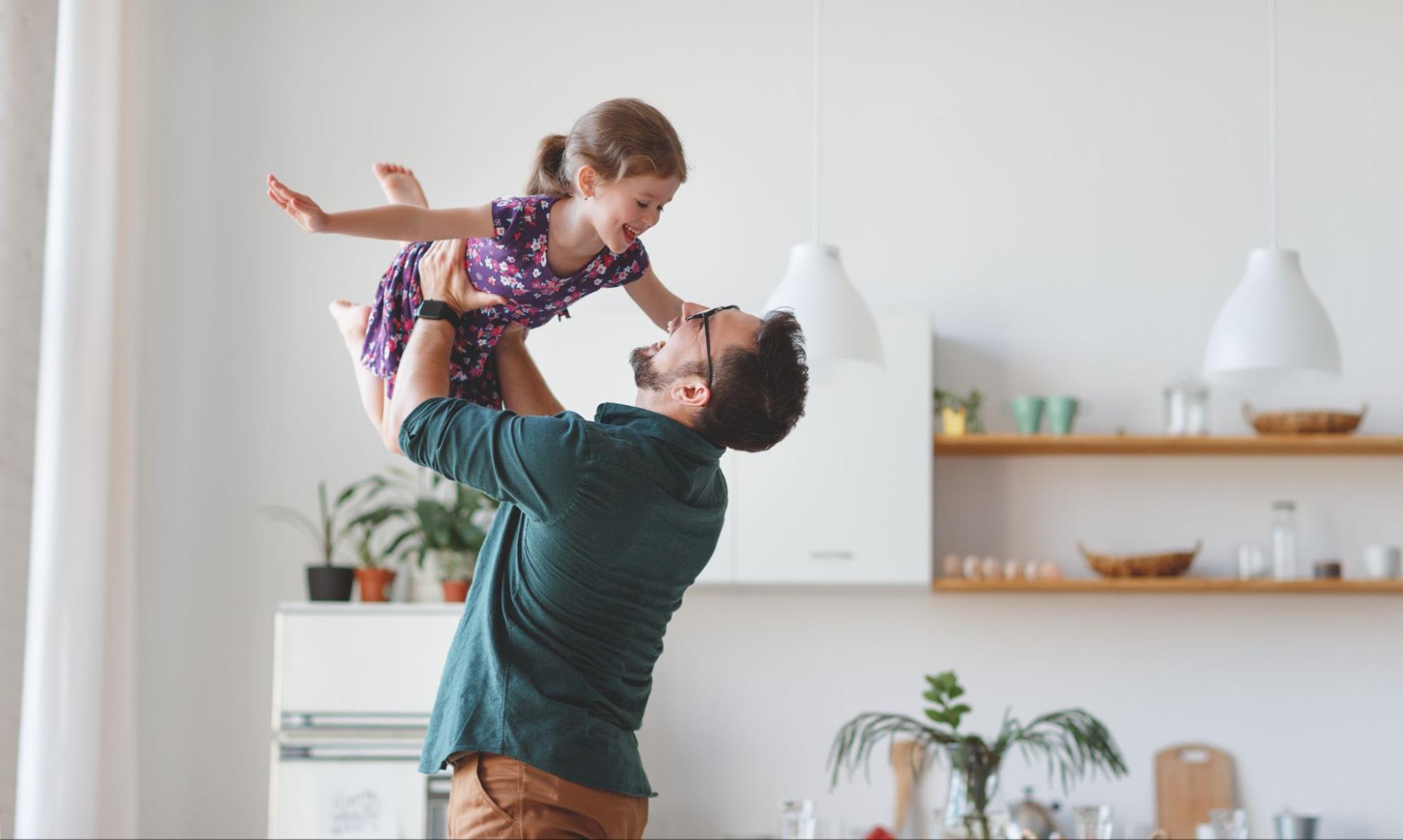 a dad lifting his daughter up in the air and spinning her around ©Evgeny Atamanenko