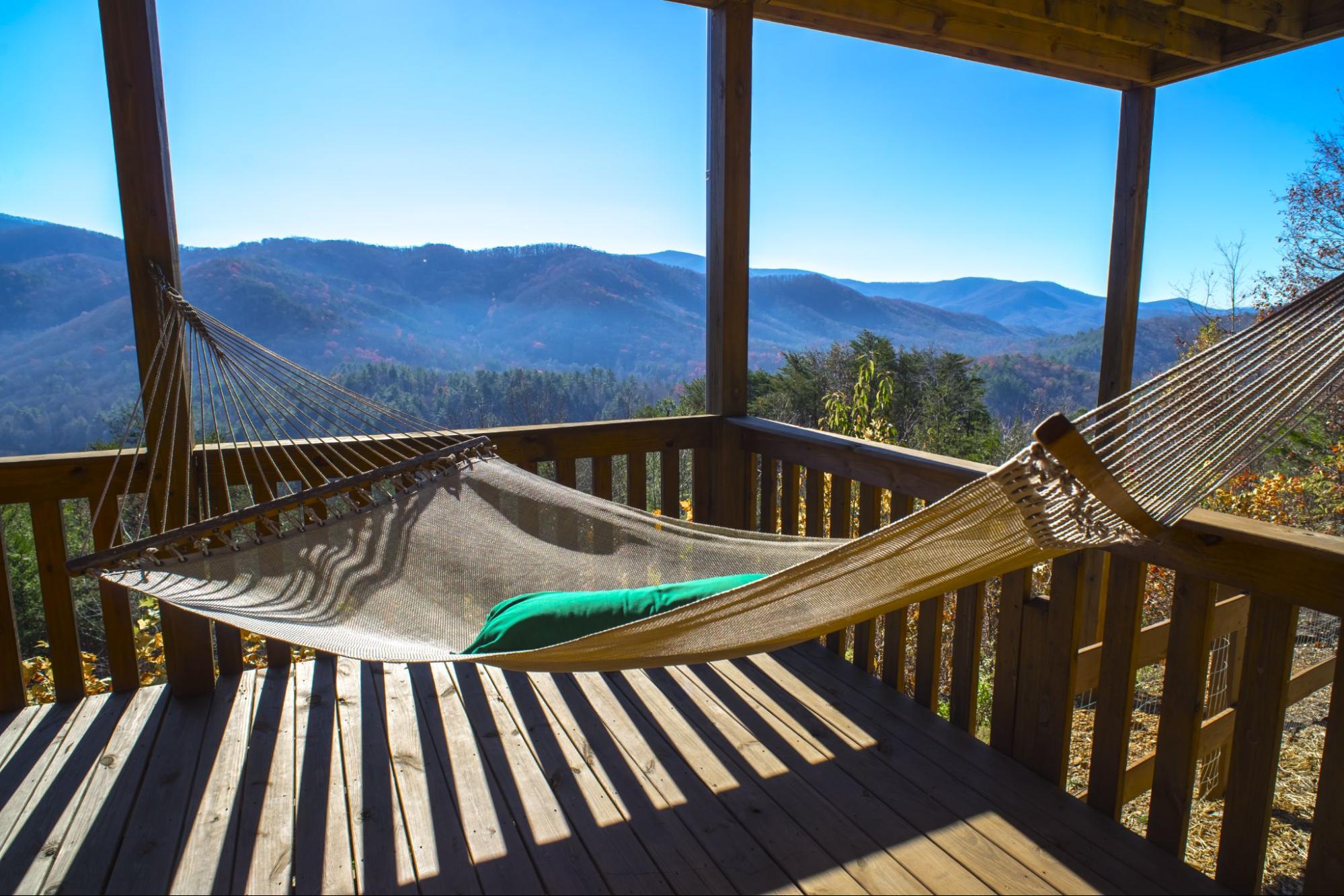 A hammock outside on the deck of a cabin with the Blue Ridge Mountains in the background.
©shark girl