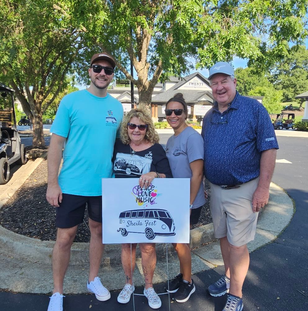Sheila Anderson from Sheila Fest 2024 holding festival sign with other residents at Traditions of Braselton.