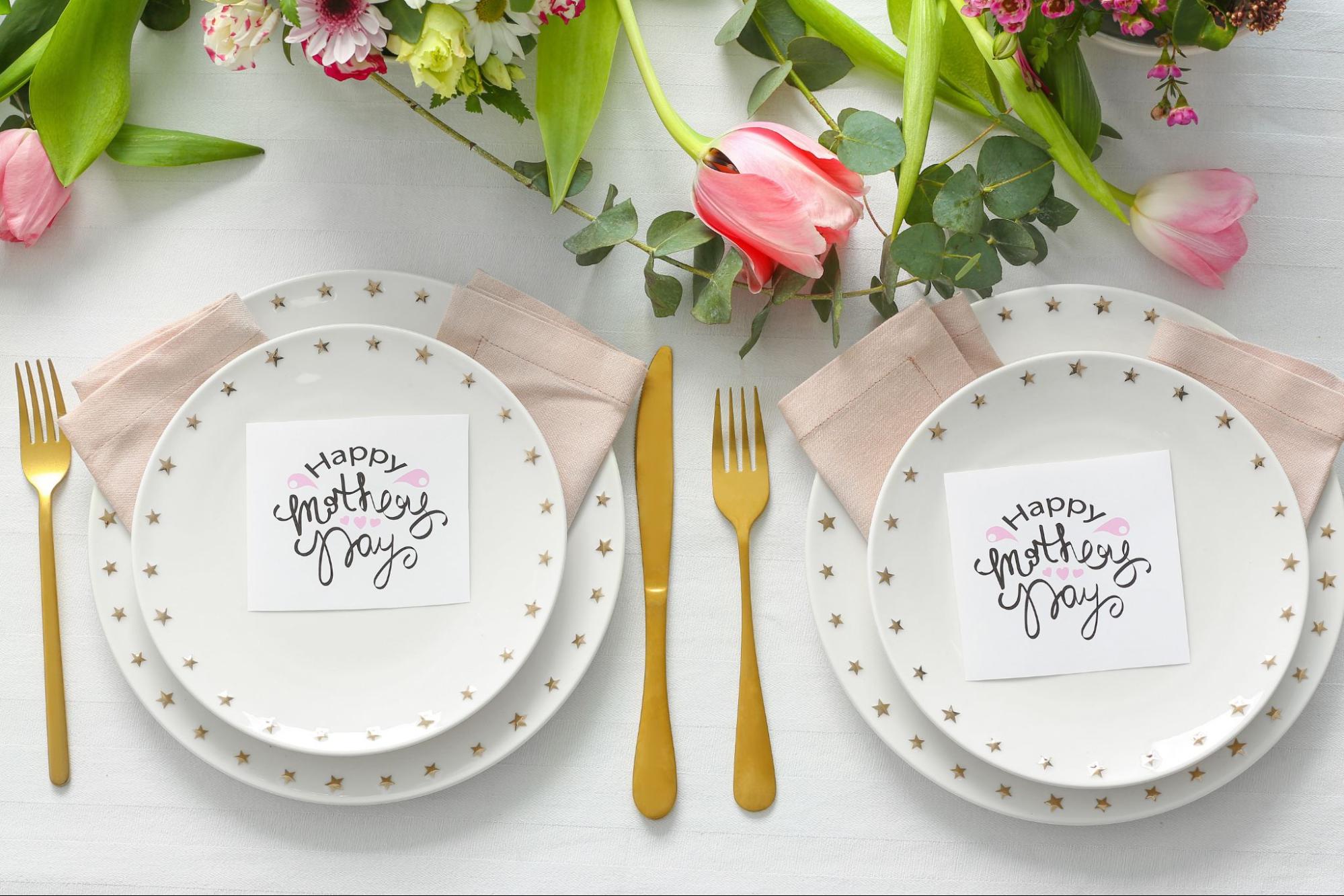 Elegant Mother’s Day table setting flat lay with star plates, pink tulips, and calligraphy cards.
©Pixel-Shot