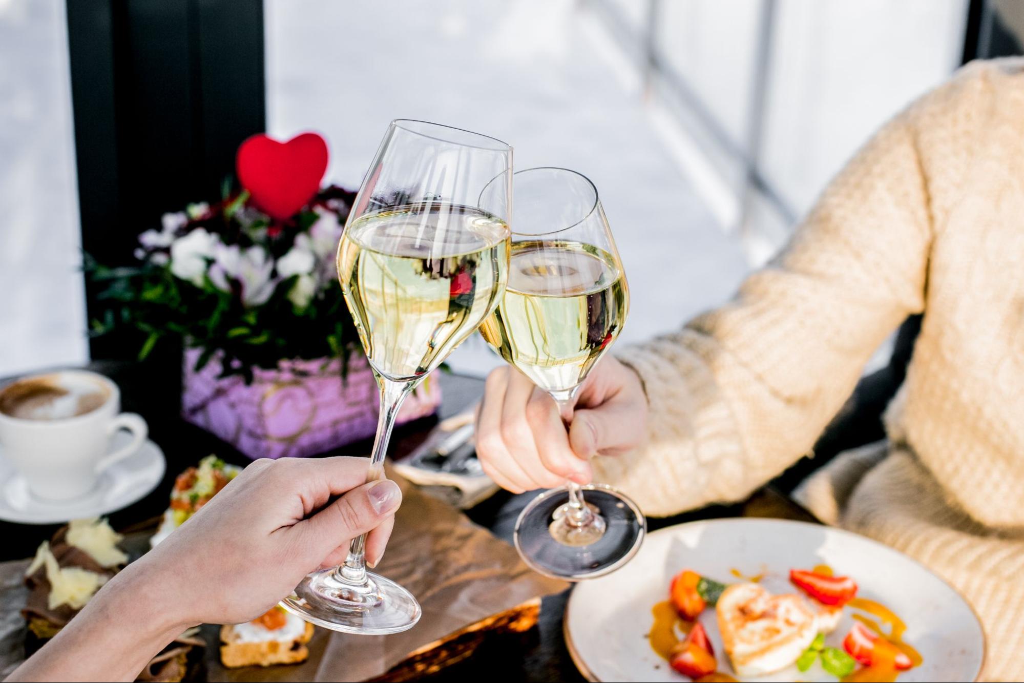 Clinking champagne flutes toast with a heart floral arrangement at Mother's Day brunch.
©Victoria Tori Dim