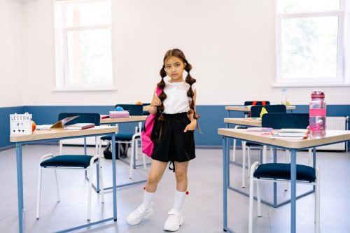 Young girl in classroom showing of her outfit for the day